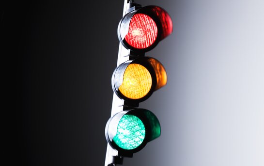 Eine Ampel mit leuchtenden roten, gelben und grünen Lichtern.