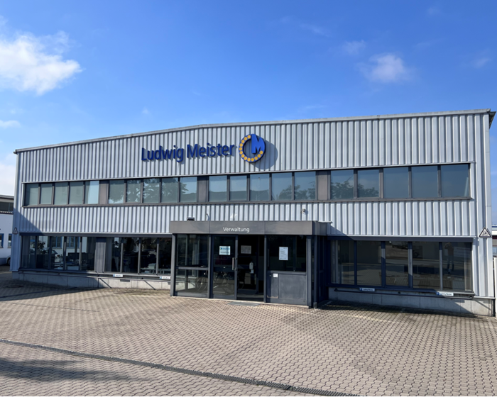 Ein modernes Verwaltungsgebäude mit dem Schriftzug "Ludwig Meister" auf der Fassade.