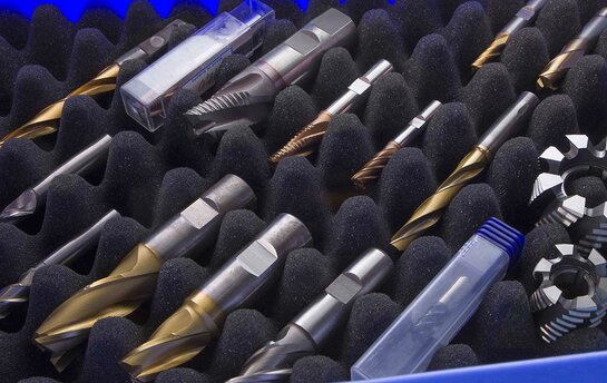 Verschiedene Präzisionsbohrer und Fräswerkzeuge organisiert in einer Schaumstoffbox.