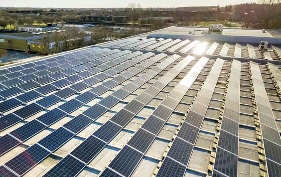 Eine große Anzahl von Solarpaneelen auf einem Flachdach, die saubere Energie erzeugen.