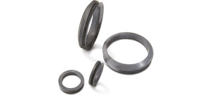 Vier verschiedene axial-wellendichtringe in unterschiedlichen Größen auf weißem Hintergrund.